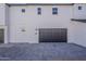Exterior view of a modern home showing garages with paver driveway at 11300 N Casa Dega Dr # 1044, Surprise, AZ 85388