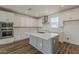 Modern kitchen with white cabinets, stainless steel appliances, gray island, and stylish backsplash at 11300 N Casa Dega Dr # 1044, Surprise, AZ 85388