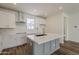 Bright kitchen featuring white cabinets, stainless steel appliances, and a gray island with a white countertop at 11300 N Casa Dega Dr # 1044, Surprise, AZ 85388