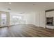Upstairs living area featuring an exit to balcony, white walls, hardwood floors, and modern appliances at 11300 N Casa Dega Dr # 1044, Surprise, AZ 85388