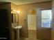 A compact bathroom with a pedestal sink, window, and shower/tub at 12639 N 113Th Dr, Youngtown, AZ 85363