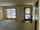 Spacious living room with natural light from a large window, freshly painted walls, and clean carpet at 12639 N 113Th Dr, Youngtown, AZ 85363