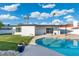 Spacious backyard with lush green lawn, pool, house, and a bright blue sky at 1317 E Verlea Dr, Tempe, AZ 85282