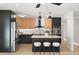 Well-lit kitchen featuring black and wood cabinets, stainless steel appliances, and a central island with seating at 1317 E Verlea Dr, Tempe, AZ 85282