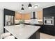 Modern kitchen featuring black and wood cabinetry, stainless steel appliances, and a bright white countertop at 1317 E Verlea Dr, Tempe, AZ 85282