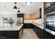 Stylish kitchen with black and natural wood cabinets, stainless steel appliances, and views of the outdoor pool at 1317 E Verlea Dr, Tempe, AZ 85282