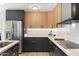 Updated kitchen featuring black and wood cabinets, stainless steel appliances, and modern lighting fixtures at 1317 E Verlea Dr, Tempe, AZ 85282