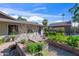 Scenic backyard with patio, brick planters, lush greenery, stone walkway, a gray brick home exterior, and blue sky backdrop at 14821 N Hana Maui Dr, Phoenix, AZ 85022