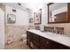 Well-lit bathroom featuring a double sink vanity with marble countertops, tile backsplash and flooring, with matching framed mirrors at 14821 N Hana Maui Dr, Phoenix, AZ 85022