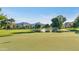 Picturesque golf course with a flag on the green, a pond, and lush trees, set against mountain views at 14821 N Hana Maui Dr, Phoenix, AZ 85022