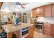 Well-lit kitchen featuring wooden cabinetry, granite countertops, stainless steel appliances and kitchen island with microwave at 14821 N Hana Maui Dr, Phoenix, AZ 85022