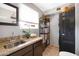 Bright laundry room with gray walls, tiled floor, utility sink, shelving, window, and modern black washer and dryer at 14821 N Hana Maui Dr, Phoenix, AZ 85022