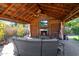 Covered outdoor living area with stone fireplace, comfortable seating, and mounted flat screen TV at 14821 N Hana Maui Dr, Phoenix, AZ 85022