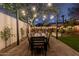 Cozy backyard features a dining table under string lights, perfect for alfresco dining and evening entertainment at 1513 W Mitchell Dr, Phoenix, AZ 85015