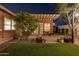 Lush backyard with brick patio, vibrant greenery, and mature trees, creating a private and serene outdoor space at 1513 W Mitchell Dr, Phoenix, AZ 85015