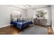 Comfortable bedroom with wrought iron bed, neutral walls and wood flooring at 1513 W Mitchell Dr, Phoenix, AZ 85015