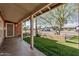 Covered porch overlooking the yard with faux grass and desert landscaping at 1513 W Mitchell Dr, Phoenix, AZ 85015