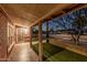 Covered porch area overlooking the yard with faux grass and desert landscaping at 1513 W Mitchell Dr, Phoenix, AZ 85015