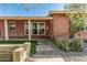 Daytime view of brick home featuring desert landscaping, stepping stones, and covered porch with a lawn at 1513 W Mitchell Dr, Phoenix, AZ 85015
