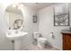 Cozy powder room featuring pedestal sink, toilet, framed mirror, and window at 1737 S Talbot --, Mesa, AZ 85209
