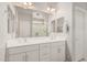Bright bathroom featuring double sinks, a large mirror, and a view of the shower at 17784 W Sandy Rd, Goodyear, AZ 85338