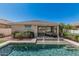 Backyard showcasing a sparkling pool with water features and lush landscaping at 17784 W Sandy Rd, Goodyear, AZ 85338