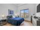 Cozy bedroom featuring hardwood floors, ample natural light from the window, and a comfortable navy-colored bed at 1805 E Rocky Slope Dr, Phoenix, AZ 85048