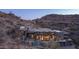 An exterior view of a custom home with high ceilings and walls of glass surrounded by desert landscaping at 1805 E Rocky Slope Dr, Phoenix, AZ 85048