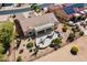 Lush backyard with a covered patio, outdoor kitchen, desert landscaping, and mature shade trees at 18514 N Laguna Azul Ct, Surprise, AZ 85374