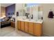 Bright bathroom featuring a double sink vanity, ample lighting, and a large mirror at 18514 N Laguna Azul Ct, Surprise, AZ 85374
