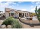 Exterior shot showcasing a desert landscaped backyard with an open patio, ideal for outdoor activities at 18514 N Laguna Azul Ct, Surprise, AZ 85374