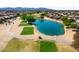 Picturesque golf course and pond surrounded by desert landscaping, lush trees, and beautiful homes at 18514 N Laguna Azul Ct, Surprise, AZ 85374