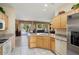 Open-concept kitchen with stainless appliances overlooking a living area and outdoor patio at 18514 N Laguna Azul Ct, Surprise, AZ 85374