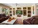 Inviting living room featuring custom built-ins, ceiling fan and neutral paint colors at 18514 N Laguna Azul Ct, Surprise, AZ 85374