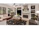 Elegant living room featuring a stone fireplace, custom built-ins, and large windows for plenty of natural light at 18867 N Cactus Flower Way, Surprise, AZ 85387