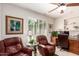 Comfortable office space with leather chairs, built-in shelves, and natural light creating a productive atmosphere at 18867 N Cactus Flower Way, Surprise, AZ 85387