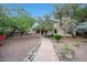Charming backyard with stone pathway leading to the home, surrounded by mature landscaping and gravel at 20838 N 39Th Dr, Glendale, AZ 85308