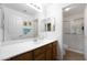 Bathroom featuring dual sinks, light oak cabinetry, a large mirror, and a sliding glass door shower at 20838 N 39Th Dr, Glendale, AZ 85308