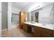 Bathroom featuring dual sinks, light oak cabinetry, and a large mirror at 20838 N 39Th Dr, Glendale, AZ 85308