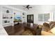 Bright living room featuring hardwood floors, a ceiling fan, custom shelving, and a decorative wood and wrought iron double door at 20838 N 39Th Dr, Glendale, AZ 85308