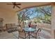 Relaxing covered patio featuring a ceiling fan, comfortable seating, and serene backyard views at 20838 N 39Th Dr, Glendale, AZ 85308