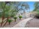 Landscaped backyard path leading to a charming storage shed amidst mature foliage and gravel at 20838 N 39Th Dr, Glendale, AZ 85308