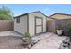 Backyard shed with stone border and gravel, surrounded by lush vegetation and privacy walls at 20838 N 39Th Dr, Glendale, AZ 85308