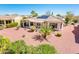 Inviting backyard oasis with desert landscaping, covered patio, and solar panels atop the home at 22236 N Arrellaga Dr, Sun City West, AZ 85375