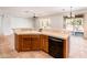 Kitchen showcasing tile countertops, wood cabinets, and a convenient breakfast bar overlooking the open living space at 22236 N Arrellaga Dr, Sun City West, AZ 85375