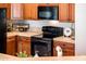 A warm kitchen featuring wood cabinets, tile countertops and black appliances at 22236 N Arrellaga Dr, Sun City West, AZ 85375