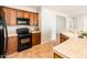 Kitchen with wooden cabinets, black appliances, and tile backsplash offering ample cooking space at 22236 N Arrellaga Dr, Sun City West, AZ 85375