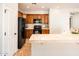 Kitchen with tile breakfast bar, ample wooden cabinets, and modern black appliances for efficient cooking at 22236 N Arrellaga Dr, Sun City West, AZ 85375