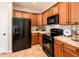 Modern kitchen featuring black appliances, sleek wooden cabinets, and tile flooring for a clean design at 22236 N Arrellaga Dr, Sun City West, AZ 85375