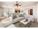 Bright open concept living room with dining area and kitchen featuring neutral decor and tile floors at 22236 N Arrellaga Dr, Sun City West, AZ 85375